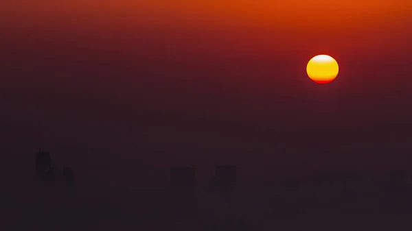 日出时分 迪拜天际线上空的近景 从迪拜码头俯瞰而过 橙色天空中的太阳在摩天大楼周围的雾气中升起 大不列颠及北爱尔兰联合王国 — 图库照片