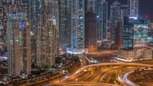 在迪拜的一个大公路交叉口上 空中的景色在夜间掠过 周围是阿联酋的摩天大楼 Jlt区的车流视图 窗户有光的照明塔 — 图库照片
