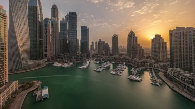 Dubai marinasında gün doğumu en yüksek gökdelenler ve yatlar güneş doğmadan önce havadan sabah saatlerinde. Apartman binalarına, otellere ve ofis bloklarına, BAE 'nin modern yerleşim alanlarına bak
