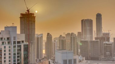 Büyük fütüristik şehir zaman diliminde havadan gün doğumu. Gökdelenleri, Dubai, Birleşik Arap Emirlikleri silueti olan iş sahası ve şehir merkezi bölgesi.