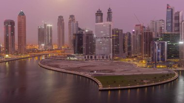 Dubai İş Koyu 'ndaki gökdelenlerin şehri. Gece gündüz su kanalları üzerinde yarımada. Ay batarken geçiş zamanı. Gündoğumundan önce aydınlık kuleleri ve rıhtımı olan modern gökyüzü.