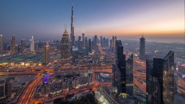 Dubai şehir merkezindeki en yüksek kulelerin havadan görüntüsü ufuk çizgisi ve karayolu günden geceye geçiş zamanı. Finansal bölge ve şehir merkezindeki iş alanı. Gökdelen ve yüksek binalar
