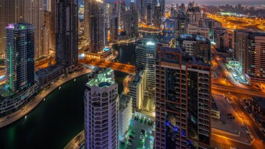 Dubai Marina hava sahasının en yüksek bloğundaki çeşitli gökdelenlerin görüntüsü suni kanallı panoramik zaman geçişi. JBR ilçesinde birçok kule ve yat gün doğumundan önce