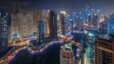 Dubai Marina hava sahasının en uzun bloğundaki çeşitli gökdelenlerin görüntüsü suni kanallı gece zaman ayarlı. Pencereleri ve yatları yanıp sönen bir sürü kule var.