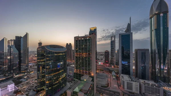 迪拜国际金融中心的摩天大楼一天到晚都在飞驰而过 明亮的塔楼俯瞰着高速公路上的车辆 — 图库照片