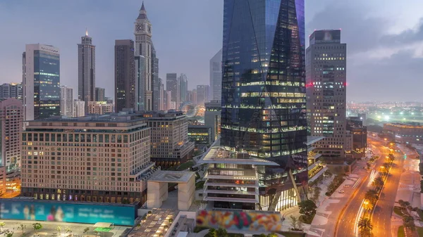 迪拜国际金融区夜以继日的过渡时间过去了 日出前商务大楼的空中景观 市中心附近有宾馆的明亮的摩天大楼 — 图库照片