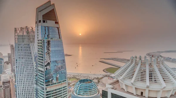 Jbrとドバイマリーナの高層ビルや豪華な建物の空中日没ビューは 上記から経過します 海に反射するオレンジ色の空にビーチと太陽と近代的な塔 — ストック写真