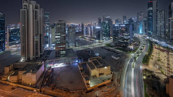 位于阿联酋迪拜的商业湾航机夜间经过 全景展现了海湾大道 带有明亮的现代塔楼住宅开发 在大停车场附近的路上堵车的摩天大楼 — 图库照片