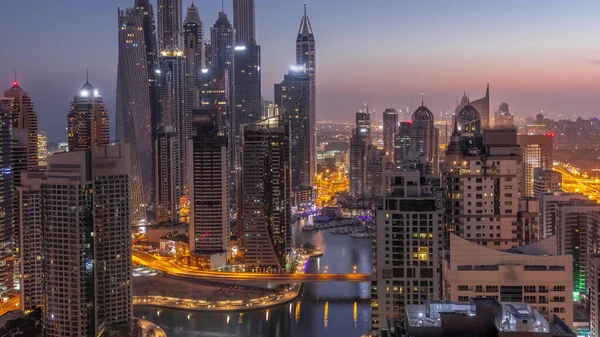 通过人工运河 可以看到迪拜码头最高交点区的各种摩天大楼从夜到日的过渡时间 日出前的许多塔楼和游艇 — 图库照片