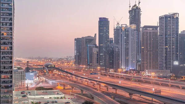 迪拜的滨海摩天大楼和谢赫扎耶德公路 与地铁从空中到夜间的过渡时间过去了 阿拉伯联合酋长国日落后靠近现代塔楼的高速公路上的交通情况 — 图库照片