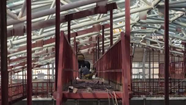 在施工现场的半自动弧焊金属加固中与电极一起工作的焊接机 穿着制服和脚手架的工人 — 图库视频影像