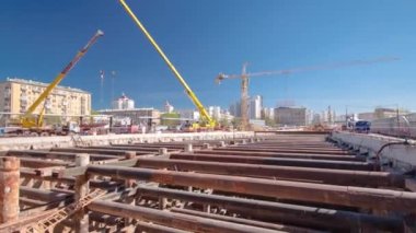 Vinçlerin zaman ayarlı olduğu büyük bir hendek tüneli. Yeraltı metro istasyonunun inşaat alanındaki kalın kirişlerden ve yapılardan oluşan demir borulardan yapıları takviye etmek.