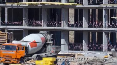 İnşaat halindeki binaları ve çok katlı evleri olan büyük bir inşaat alanı. Beton karıştırıcı devrede. Konut yenileme konsepti. İşlem sırasında turna