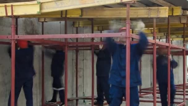 建筑工人向上移动钢棒 用脚手架和高耸建筑的工具加固混凝土 摩天大楼 正在建造的大楼 — 图库视频影像