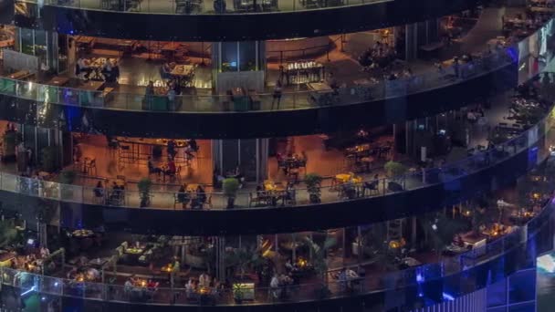 迪拜的码头和灯光明亮的大楼 每层空中夜间都有不同的餐厅 可以俯瞰全景 吃饭的时候 人们坐在桌旁休息 — 图库视频影像
