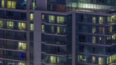 Yüksek katlı binalardaki pencere ışıkları geceleri zaman ayarlı. İçinde aydınlık odalar olan çok katlı gökdelenler.