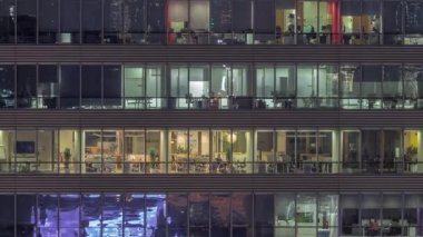 Ofis binalarının gece saatlerinde pencereleri gökdelenlerin pencerelerinden gelen ışık manzarayı kapatıyor. Şehrin akşam manzarası ışıl ışıl çalışıyor.