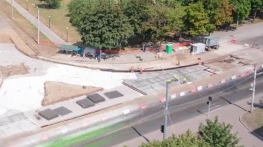 Tramvay rayları onarılan ve panoramik panoramik zaman ayarlı yol inşaatı. Beton kavşağın orta kısmında işe yarar. Metal kablolarla çalışır