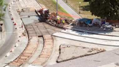 Tramvay rayları onarımı ve bakım havası olan bir yol inşaatı. Turuncu karıştırıcı kavşağın ortasına beton döküyor. Yeni toplu taşıma için demiryolu raylarının değiştirilmesi