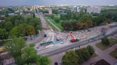 Tramvay rayları onarılan ve panoramik panoramik zaman ayarlı yol inşaatı. Kavşağın ortasında vinç üstüne beton plaka yükleme ve yükleme ve bloklar