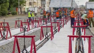 Kurulum aşamasındaki tramvay rayları ve zaman dilimindeki beton plakalara entegrasyon. İşçiler, demiryolu konfor sistemi için anti-titreşim reçinesi koyuyorlar. İşlem...