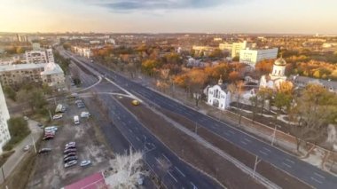 Hava rengarenk gün batımı görüntüsü ve yol trafiği gökyüzü zaman çizelgesi. Moskova Bulvarı yeniden inşa edilmiş karayolu ve yerleşim bölgeleriyle yukarıdan Kharkiv şehri akşam ışığında arka planda