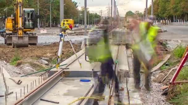 作業者は ルートのタイムラプスの再構築中にコンクリートプレート上に新しいトラムレールを取り付け インストールするための穴をドリルダウンします 路面電車の近代化 — ストック動画