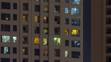 Dışarıdaki renkli binaların gece görüşü zaman ayarlı. Pencerelerinde parlayan ışıklar olan yüksek gökdelen