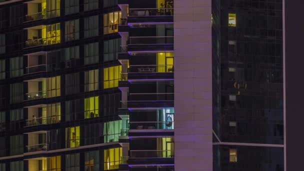 外観のアパートカラフルな建物のタイムラプスの夜景 高層ビルの窓から光が差し込む高層ビル — ストック動画
