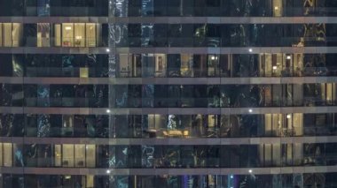 Gece vakti üst sınıf bir binanın pencerelerinin önünde oturuyorlardı. Gökdelende yansımalı parlayan ışıklar