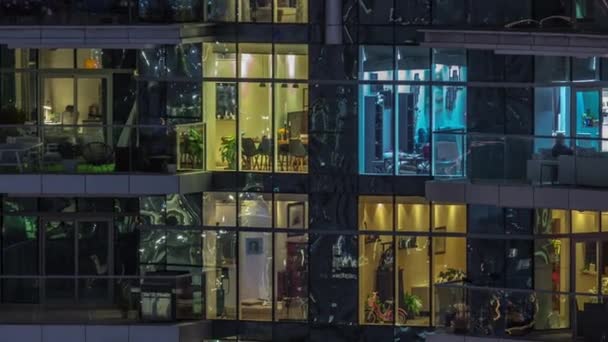 マルチ階建ての建物の大きな窓の多色光のフラット夜のパノラマ空中タイムラプス 大都市のライトアップされた超高層ビル — ストック動画