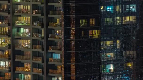 夜のタイムラプスでのアパートの建物の窓 家の照明された部屋からの光 高層ビルの都市景観 — ストック動画