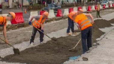 Buldozer taşır ve toprak ve moloz yol timelapse üzerinde yayılır. İşçiler turuncu bir tramvay inşası Tekdüzen izler. Yol yapım aşamasında.