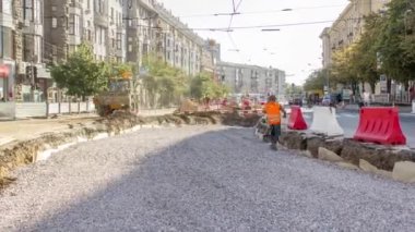 Buldozer hareket eder ve ezilmiş taş ve molozları zaman çizgisine yayar. Tramvay raylarının yeniden inşasında kazıcı olarak çalışıyorum. Yol yapım aşamasında. Havadan üst görünüm