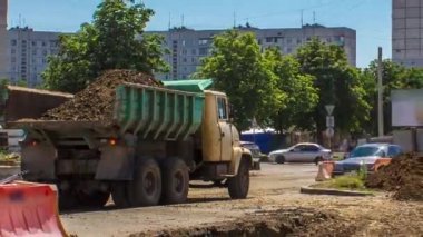 Endüstriyel kazı alanı kazma ve bir yol inşaatında bir kamyonun zaman tüneline yükleme. Büyük bir şehirde tramvay raylarının yeniden inşasına hazırlık