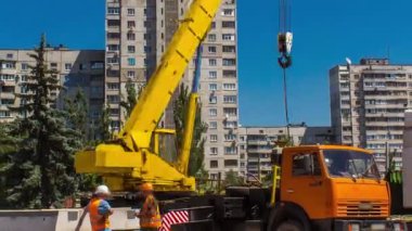 Yol inşaatı zamanında vinçle beton plakalar boşaltılıyor. Şapkalı ve üniformalı endüstriyel işçiler. Şehir caddesindeki tramvay raylarının yeniden inşası