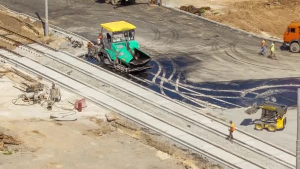 沥青摊铺机 压路机和卡车在路面修整过程中通过 有轨电车轨道重建的空中俯视图 公路建筑设备 道路上的建筑工人 — 图库视频影像