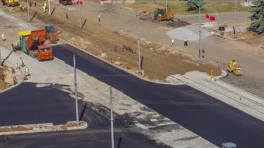 Asfalt kaldırım taşı, paten ve kamyonun asfaltlama zamanındaki havadan görüntüsü. Tramvay izleri yeniden inşa ediliyor. Yol yapım ekipmanları. Yol onarımı yapan inşaat işçileri.