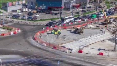 Büyük bir şehir kavşağının havadan görünüşü ile yol inşaatı alanındaki kentsel işler zaman ayarlı. Tramvay raylarında vinçleri, kamyonları, tekerlekleri ve buldozerleri olan birçok endüstriyel ekipman. Trafik vardı.