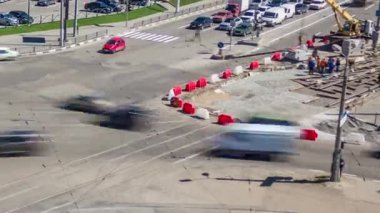 Vinç panoramik zaman dilimine göre beton plakalar döşenmiş bir yol inşaatı. Şapkalı ve üniformalı endüstriyel işçiler. Şehir caddesindeki tramvay raylarının yeniden inşası