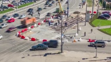 Yukarıdan vinç ile beton plakalar döşenmiş bir yol inşaatı. Şapkalı ve üniformalı endüstriyel işçiler. Şehir kavşağındaki tramvay raylarının yeniden inşası