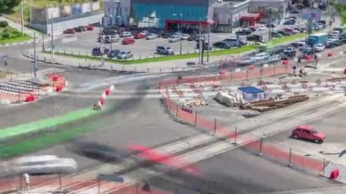 Büyük bir şehir kavşağının havadan görünüşü ile yol inşaatı alanındaki kentsel işler zaman ayarlı. Tramvay raylarında birçok endüstriyel ekipman var. Kavşakta trafik vardı.