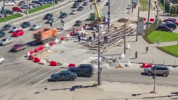 クレーンによるコンクリートプレートを設置する道路建設現場は 上記から経過します ハード帽子と制服を着た工業労働者 市街地交差点における軌道の再建 — ストック動画