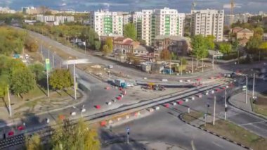 Şehir kavşağındaki asfaltlamanın hava görüntüsü yol inşaatı alanındaki kentsel çalışma zamanı. Tramvay raylarında birçok endüstriyel ekipman var. Kavşakta trafik vardı.