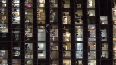 Gökdelenler Uluslararası İş Merkezi 'nin parıldayan ofis pencerelerine yakından bakın. Büyük bir şehirde, gece vakti tepeden. Portre kipinde sosyal medya için dikey ekran videosu