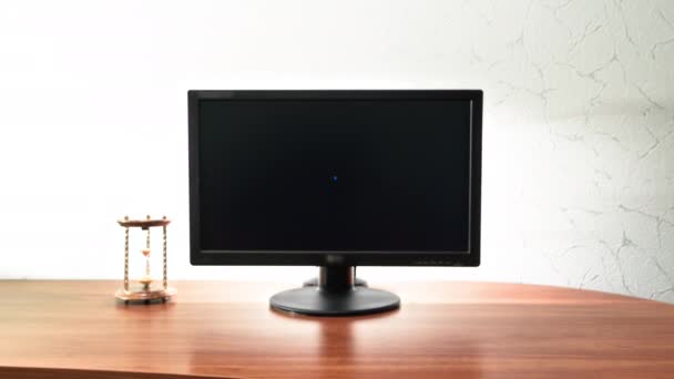 工作台为数字作业配备计算机 沙漏接近监视器时间差超差 移动到黑屏上 — 图库视频影像