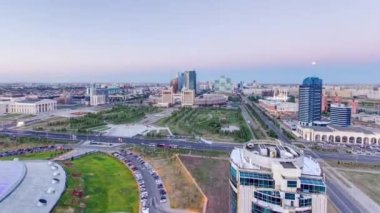 Şehir merkezi ve merkez iş bölgesi üzerindeki manzaranın günden geceye yükselmesi geçiş zamanı çatısı, Orta Asya, Kazakistan, Astana