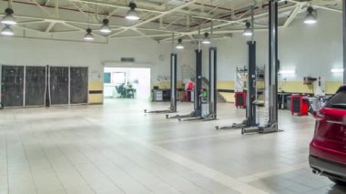 Modern benzin istasyonunda arabalar hareket eder ve erkekler arabaları tamir eder. Zaman geçtikçe hızlanır. Arka planda oto yıkama kutuları