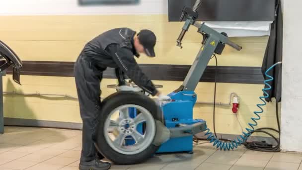 汽车修理工在汽车维修服务时间内更换车轮上的轮胎 平衡轮与使用中的机械平衡器 — 图库视频影像