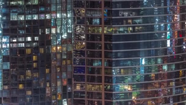 夜遅くに高層オフィスビルの外観の窓は タイムラプスに輝くと点滅インテリアライト 空中展望 — ストック動画